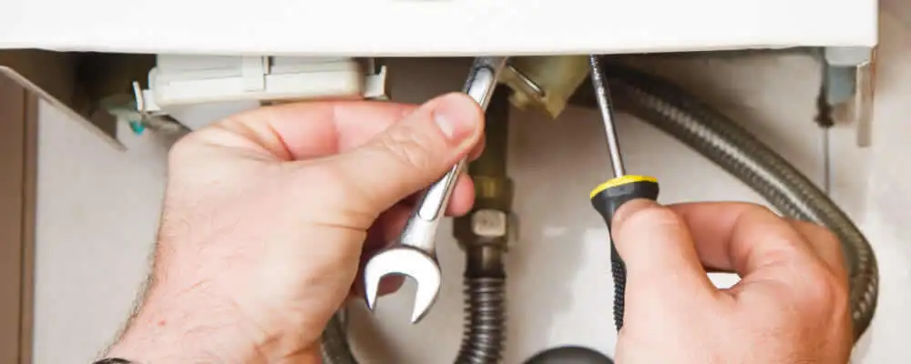 Boiler repair technician tightening pipe fittings and connections in Berkeley, CA