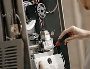 Furnace repair technician inspecting internal components and wiring in Berkeley, CA